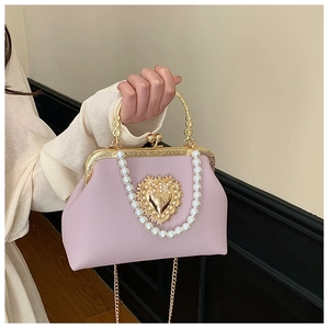Detail of light pink Baroque clutch with gold heart buckle and pearl chain handle