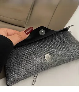 Detail of silver sequined evening bag showing magnetic closure and metal chain strap