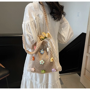 Détail du sac filet en crochet beige avec des fleurs colorées en tricot 3D et pétales
