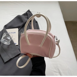 Close-up of pastel pink and cream contrast handbag with detachable shoulder strap