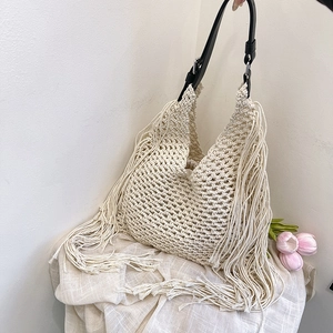 Bohemian off-white woven net tote bag with fringe details and black leather straps