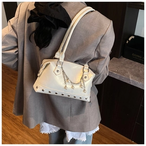 Detail of white glossy rivet tote bag with pearl charms and metal chain on model