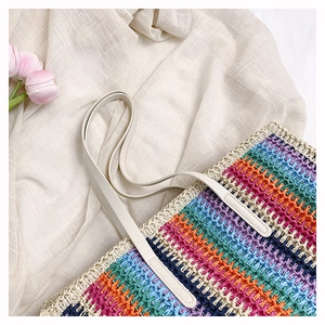 Close-up of rainbow straw tote bag with multi-color stripes and beige faux leather handle