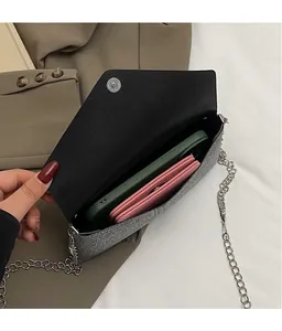 Detail view of silver sequin chain bag interior holding a phone and long wallet