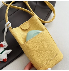 Détail du mini sac à bandoulière jaune avec texture litchi et charmant canard blanc
