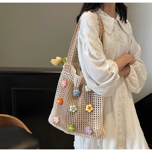 Détail d'un sac cabas en crochet beige orné d'appliques florales 3D colorées faites main