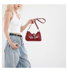 Detail der roten Lackleder-Punk-Tasche mit silbernen Spikes auf dem Trageriemen