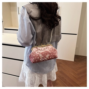 Détail du sac coquille en velours rose avec perles blanches et broderie de dentelle papillon