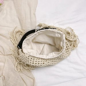 Handwoven cream tote bag with long tassels and black leather shoulder straps