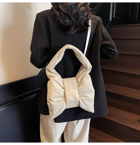 Detailed view of the creamy white quilted tote bag featuring a large bow shape design