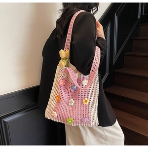 Détail de fleurs 3D au crochet sur un sac cabas ajouré en maille beige et rose