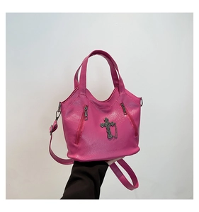 Detail of pink faux leather tote with metallic cross pendant and side zipper pockets