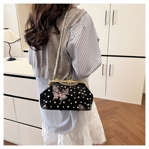 Vue détaillée du sac en velours noir avec broderie papillon et bandoulière perles