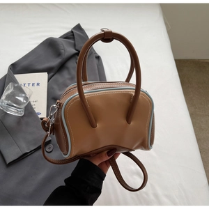 Close-up of contrast color bowling bag with blue edges and brown faux leather detail