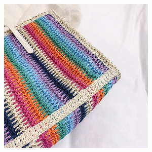 Detail of colorful rainbow straw tote bag showing vibrant woven texture and white border
