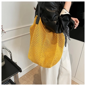 Detail of yellow hollow crochet tote bag showing woven texture and spacious interior