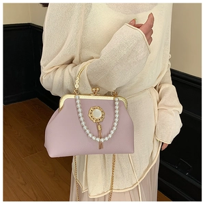 Detail of lavender baroque style handbag with pearl emblem and metallic fringe