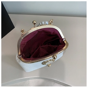 Detailed interior of vintage white pearl bag with luxury red satin lining and metal clasp