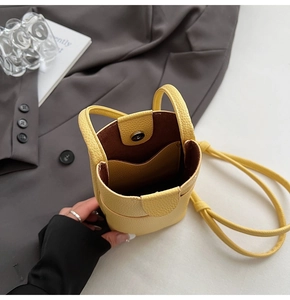 Détail intérieur du mini sac jaune à motif litchi avec boucle aimantée et poche interne