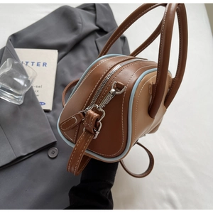Close-up of retro color-block bowling bag with blue piping on a gray suit jacket