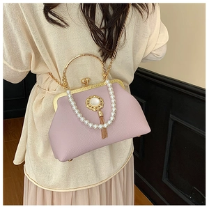 Close-up of lilac Baroque clutch bag with large pearl handle and vintage gold tassel detail