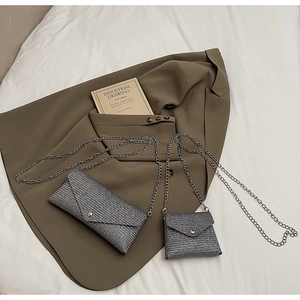Detail of silver-grey chain bag set showing fine woven texture and magnetic metal clasp
