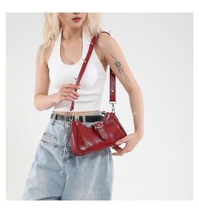 Detail der roten Lackleder-Schultertasche mit silbernen Punk-Spikes und Metallschnalle