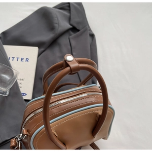 Detail of two-tone bowling bag with blue trim, silver buckles and metal zipper