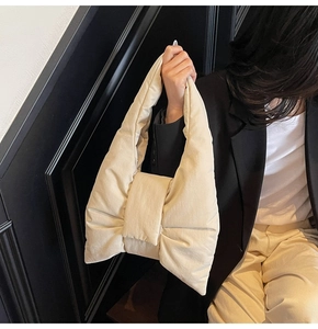 Detailed view of the oversized cream bow nylon tote bag with puffer padding effect