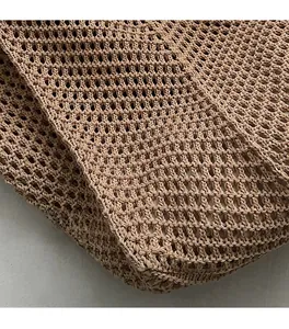 Macro view of khaki hand-knitted tote bag showing mesh weave texture and fabric lining