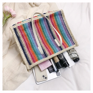 Top-down shot of a large rainbow straw tote bag showing spacious interior with daily items