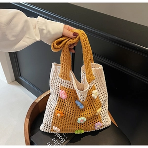 Détail du sac cabas en tricot ajouré avec fleurs au crochet et texture détaillée
