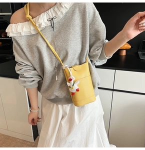 Gros plan sur le sac de téléphone vertical jaune vif avec texture et charm de canard