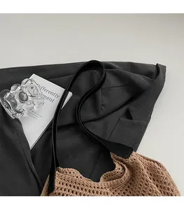 Detail showing comfortable black shoulder strap and hollow woven tote bag texture