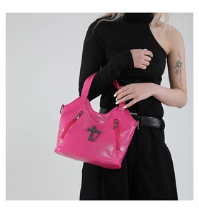 Close-up of hot pink gothic tote bag featuring metallic cross and chain details