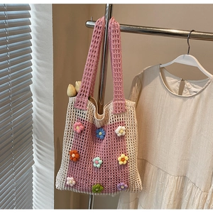Détail du sac cabas au crochet rose et beige avec des motifs de fleurs colorées