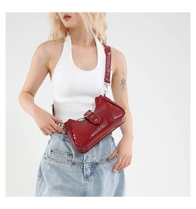 Vue détaillée du sac à bandoulière en cuir verni rouge avec clous argentés sur la sangle