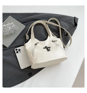 Detail of white litchi pattern tote with black metal cross charm and retro silver zippers