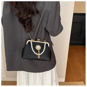 Detailed view of Baroque black leather frame bag with pearl handle and golden tassel jewel