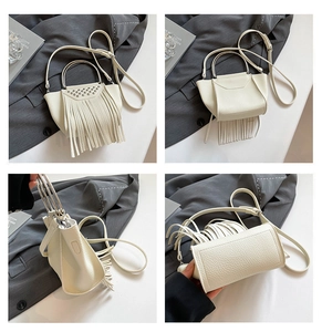 Dettaglio borsa bianca in pelle con frange, manico ad anello in metallo e rivetti