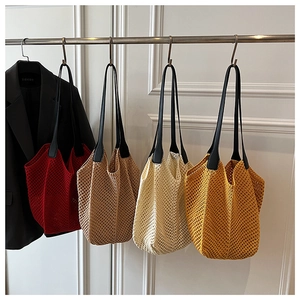 Detail view of colorful crochet tote bags with leather handles and openwork knit texture