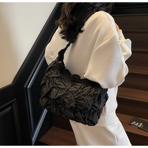 Detail of black pleated cloud shoulder bag showing premium nylon texture and large capacity