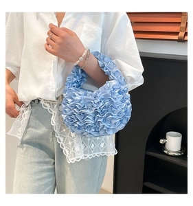Close-up of light blue pleated satin handbag with ruffled design and silky texture