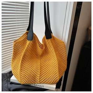 Detail of hand-woven bright yellow tote bag with reinforced black faux leather straps