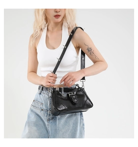 Détail du sac bandoulière noir brillant avec clous punk argentés et boucle métallique