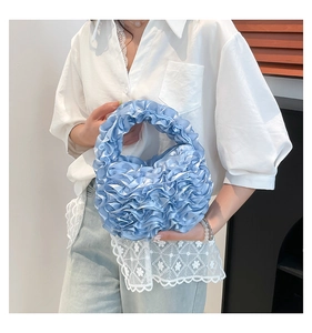 Close-up of light blue ruffled tulle handbag with detailed pleated fabric texture