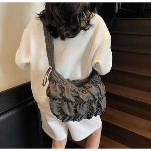 Detail of dark grey pleated cloud bag in soft nylon with wide shoulder strap design