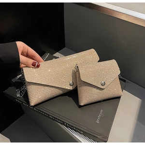 Macro detail of champagne gold envelope evening bag with shimmering glitter finish