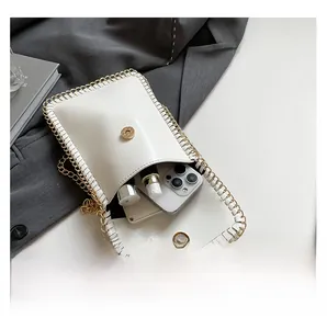 Internal capacity of the white leather mini chain bag showing smartphone and lipsticks