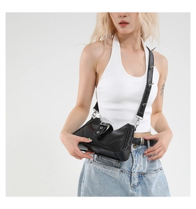 Détail d'un sac bandoulière punk en cuir noir avec des clous métalliques sur la sangle d'épaule